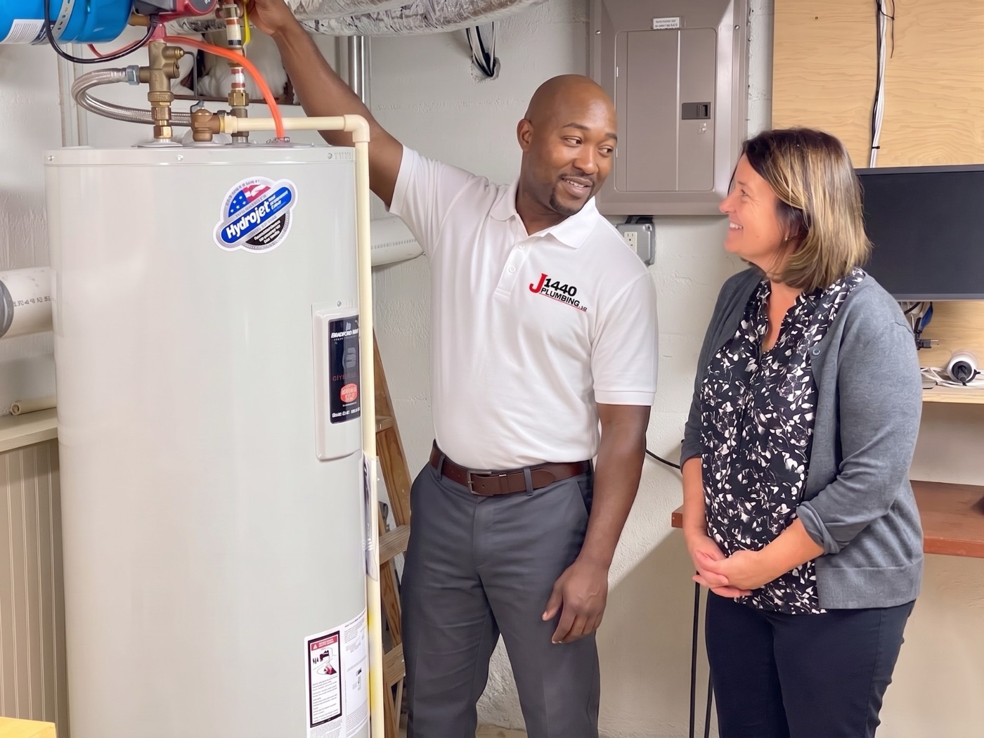 J1440 plumber explaining a newly installed Bradford White water heater to a homeowner